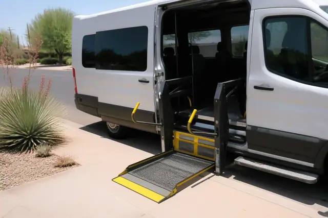 Transport van with a deployed hydraulic wheelchair lift parked on a street in Phoenix, AZ.