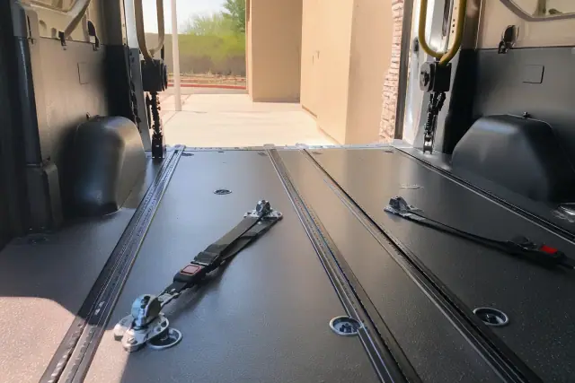 Wheelchair securement floor tracks and four-point tie-down straps inside a vehicle in Phoenix, AZ.