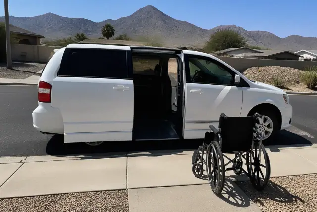 Medical transport vehicle with open side doors for passenger boarding at a curbside in Phoenix, AZ.