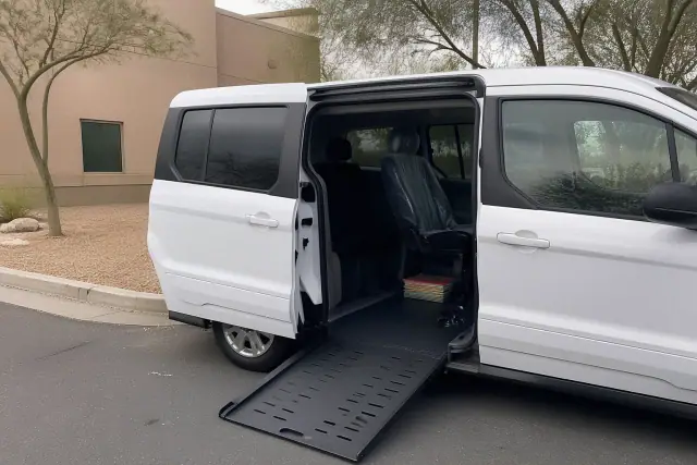 Accessible transport van with a lowered ramp parked at a dialysis clinic in Phoenix, AZ.