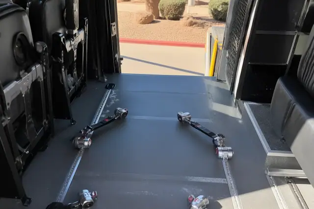 Wheelchair securement station with tie-down straps inside a transport vehicle in Phoenix, AZ.