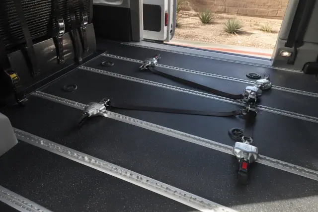 Wheelchair securement station with four-point tie-down straps in a transport vehicle in Phoenix, AZ.