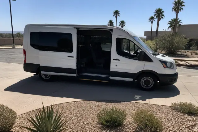 Medical transport van parked at a curbside pickup location with desert landscaping in Phoenix, AZ.