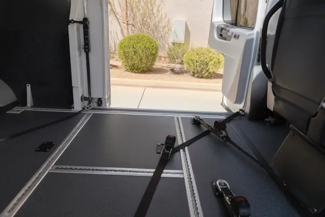 Interior of a medical transport vehicle with floor tracking systems and tie-down straps in Avondale, AZ.