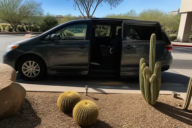 A medical transport van parked curbside with open doors in a sunny Scottsdale, AZ desert landscape.