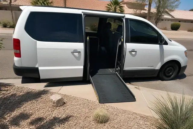 Medical transport vehicle with open side doors for boarding assistance parked on a desert street in Sun City, AZ.