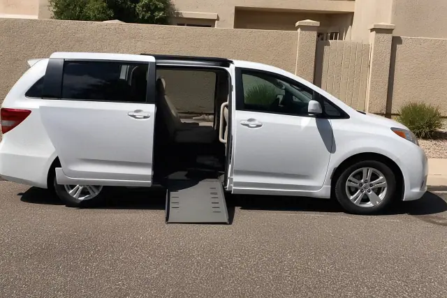 Medical transport vehicle with side doors open for boarding parked by a stucco wall in Gilbert, AZ.