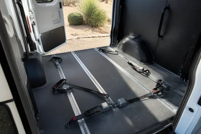 Wheelchair securement station with tie-down straps inside a medical transport van in Phoenix, AZ.
