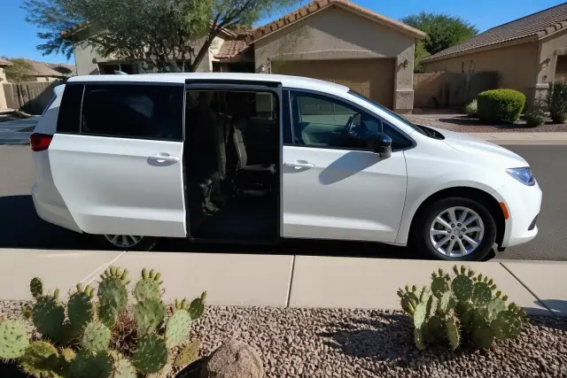 Medical transport vehicle with open side doors parked curbside at a home in Chandler, AZ.
