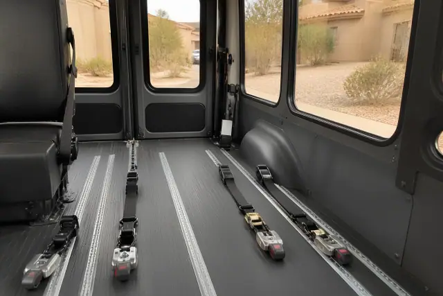 Wheelchair tie-down straps and floor tracking system inside a medical transport van in Peoria, AZ.
