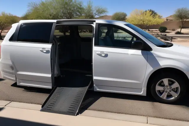 Medical transport van with its side door and mobility ramp deployed on a driveway in Surprise, AZ.