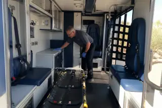 Technician inspecting the medical cabinet and safety restraints inside a transport van in Phoenix, AZ.