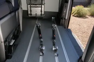 Wheelchair securement station with floor tracking and tie-down straps in a transport van in Phoenix, AZ.