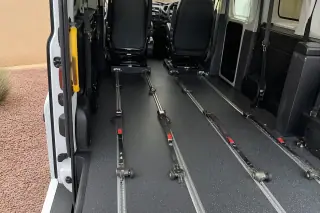 Interior floor tracking and heavy-duty tie-down straps inside a medical transport van in Phoenix, AZ.