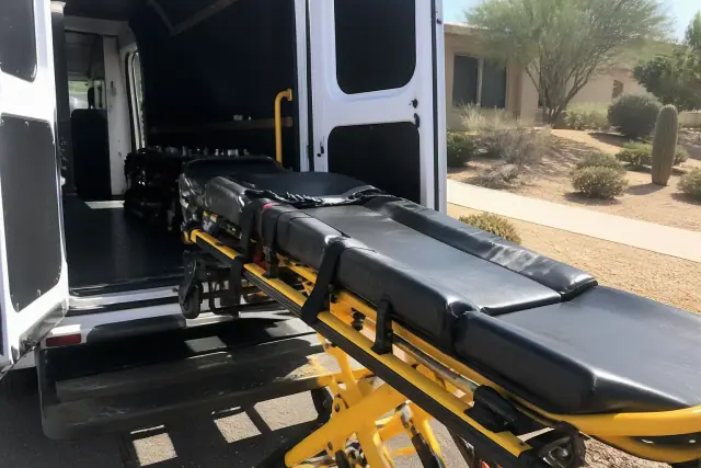 Stretcher being loaded with safety belts and locking mechanisms at a vehicle in Glendale, AZ.