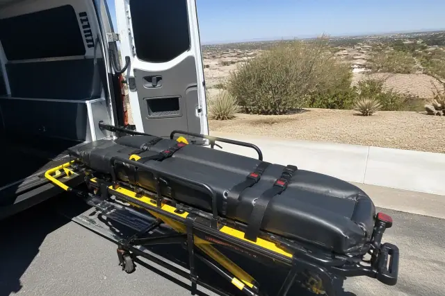 Stretcher secured at the rear of a transport van during a loading procedure in Phoenix, AZ.