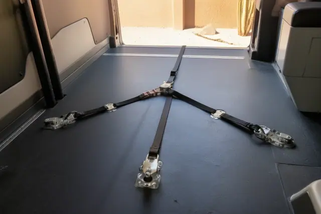 Wheelchair tie-down straps secured to a vehicle floor track at a jobsite in Phoenix, AZ.
