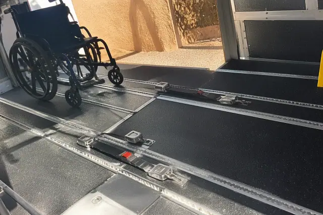 Wheelchair securement station with floor tracking and tie-down straps in a transport van in Phoenix, AZ.