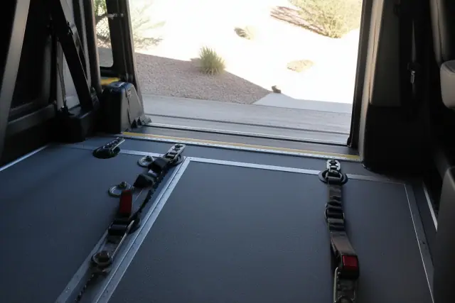 Wheelchair securement station with floor tracking and tie-down straps inside a vehicle in Phoenix, AZ.