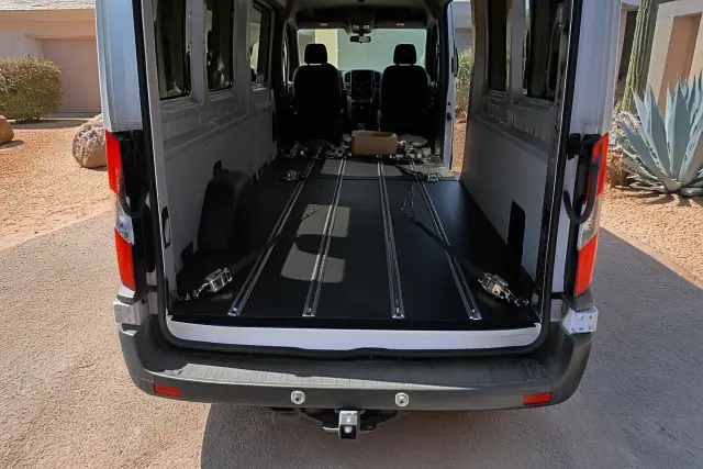 Wheelchair securement straps anchored to a vehicle floor at a residential driveway in Phoenix, AZ.