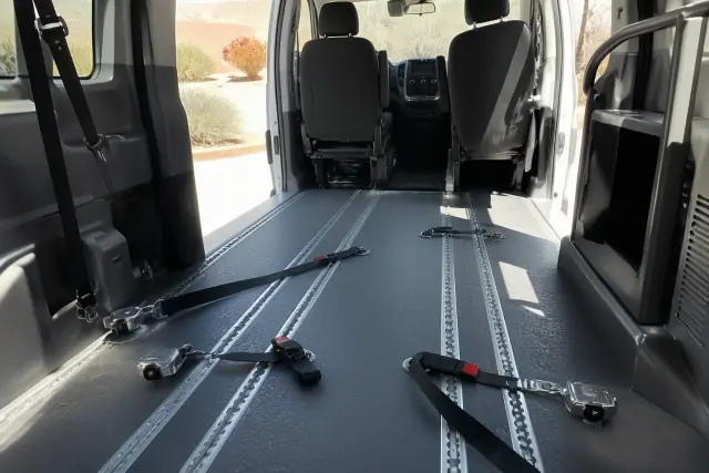 Wheelchair transportation vehicle interior with floor tracks and four-point tie-down straps in Tempe, AZ.