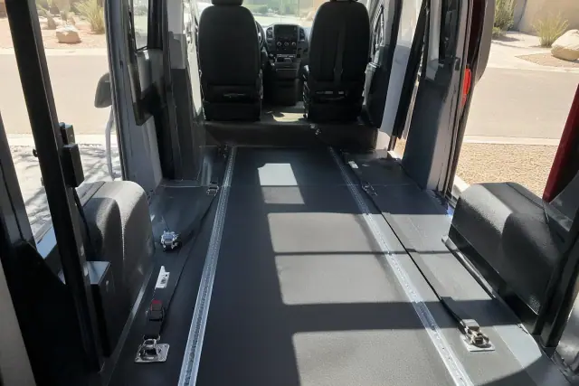 Interior of a wheelchair-accessible medical transport van with floor tie-down straps in Phoenix, AZ.