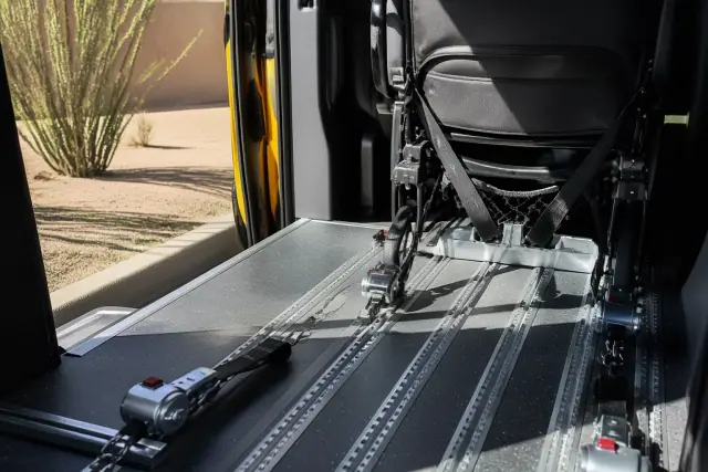 Interior of a wheelchair transport vehicle with floor tracking and secured tie-down straps in Phoenix, AZ.