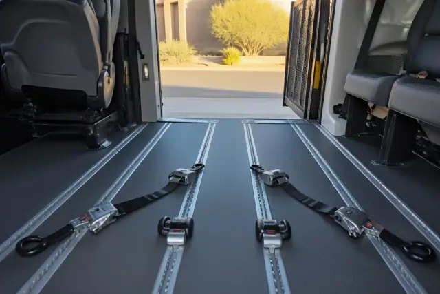 Wheelchair securement straps and floor tracking system inside a medical transport van in Avondale, AZ.