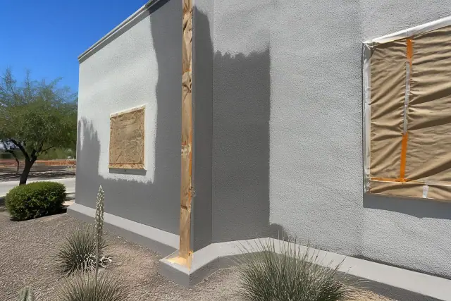 Stucco wall with 100% acrylic exterior coating and protective masking at a commercial job site in Phoenix, AZ.