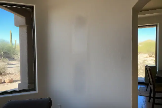 Visible sheen mismatch and texture difference on a patched drywall crack in a residential home in Phoenix, AZ.
