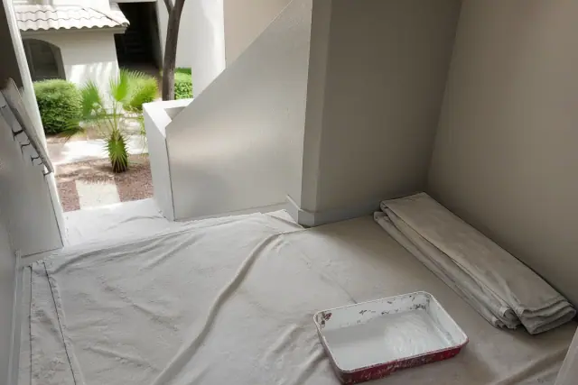 Interior stairwell of an apartment building in Tempe, AZ, with drop cloths and painting supplies on the floor.