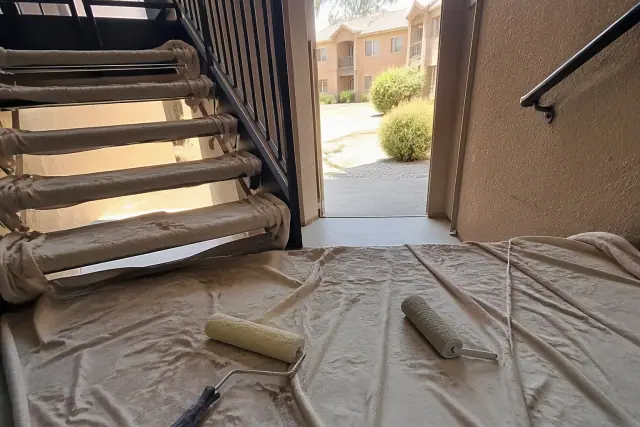 Paint rollers on drop cloths in a residential stairwell during a painting project in Surprise, AZ.