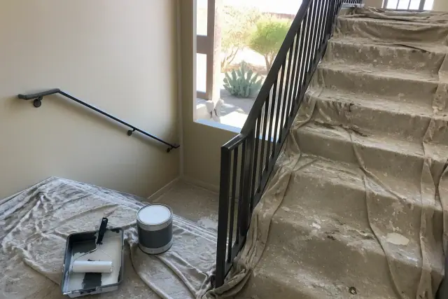Painter's drop cloths and equipment on concrete stairs in a Glendale, AZ multifamily stairwell.