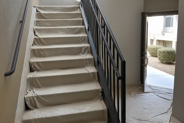 Freshly painted interior stairwell at an apartment complex in Peoria, AZ, with drop cloths on the steps.