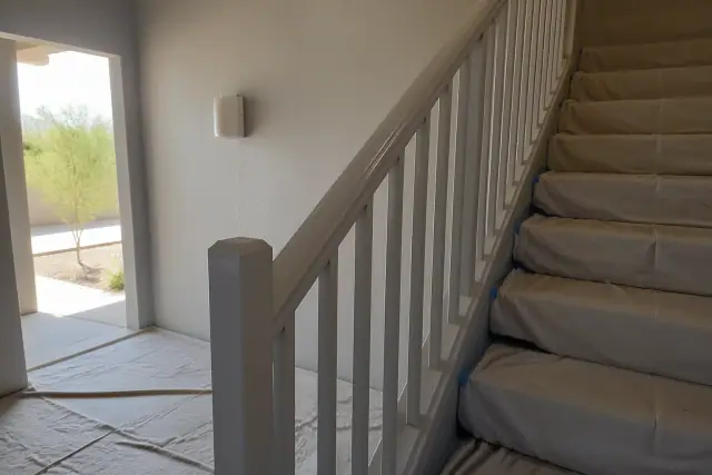 Freshly painted stairwell railings with drop cloths in a residential apartment complex in Goodyear, AZ.