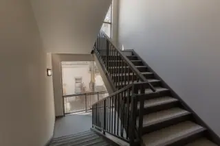 Finished interior stairwell with painted railings and desert views through a window in a Phoenix, AZ apartment building.