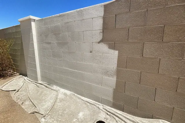 Half-finished masonry wall painting project on a cinder block structure in Glendale, AZ.