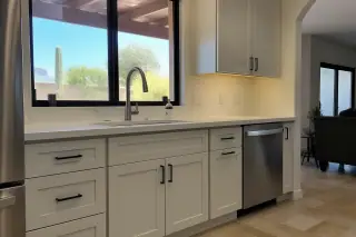 Dismantled kitchen cabinet doors drying on racks in a Phoenix, AZ workshop.