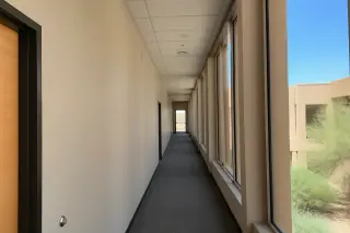Freshly painted hallway in a Phoenix, AZ professional building with bright sunlight through high windows.