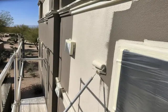 Contractor view of a multi-story clubhouse being painted with wet roller marks and masking tape in Phoenix, AZ.