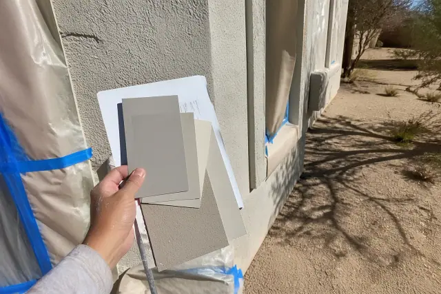 Complete ARC paint submission packet against a stucco wall at a Phoenix, AZ worksite with masking paper and painter's tape.