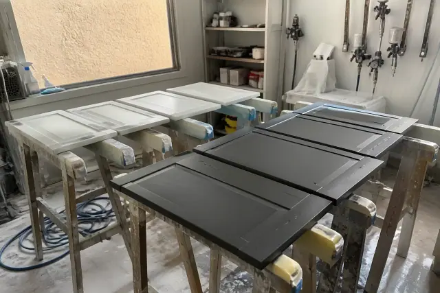 Cabinet doors on drying racks during a painting project in a workshop in Phoenix, AZ.