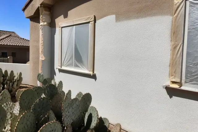 Elastomeric coating applied to a stucco house exterior near prickly pear cactus in Phoenix, AZ.