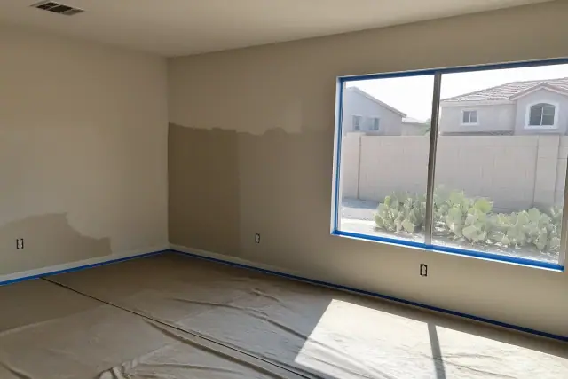 Drywall repair and fresh paint with painter's tape in a living room in Surprise, AZ.
