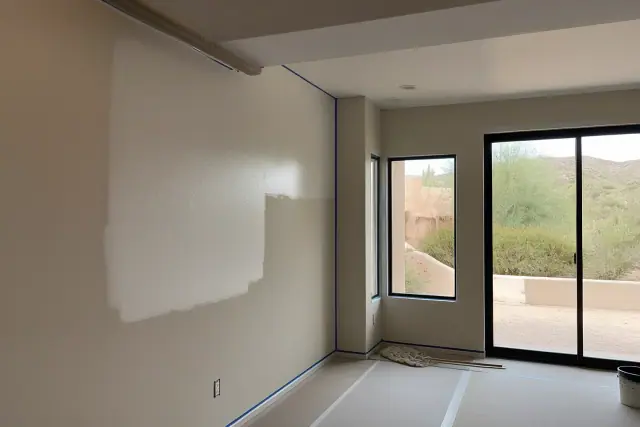 Painter applying fresh paint to living room walls in a home in Paradise Valley, AZ.