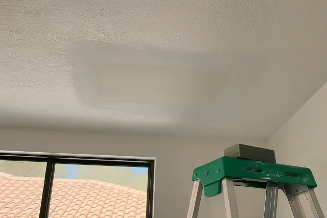 Freshly sanded drywall patch on a ceiling in a residential room in Tempe, AZ.
