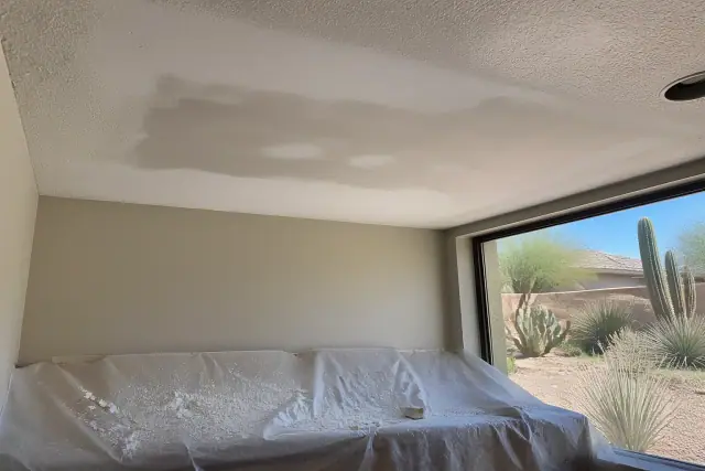 Sanded drywall ceiling repair with dust on a drop cloth in a Scottsdale, AZ home.