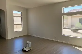 Freshly painted living room walls with a paint bucket and roller tray in a Phoenix, AZ home.