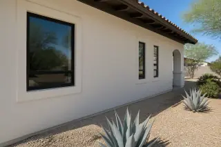 Finished stucco exterior wall with agave plants and desert shade at a home in Phoenix, AZ.