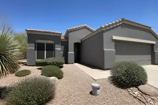 Finished exterior stucco wall with uniform paint and desert landscaping at a home in Phoenix, AZ.